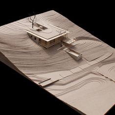 an architectural model of a house in the middle of a desert with trees on top