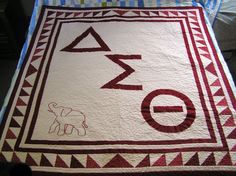 a quilt with an elephant and letters on it