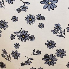 blue flowers on white fabric with yellow centers and small black dots in the center,