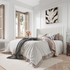 a bedroom with white walls and wooden flooring has a large bed in the center