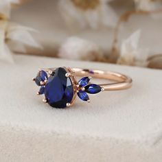 a close up of a ring with a blue stone on the front and two smaller blue stones on the back