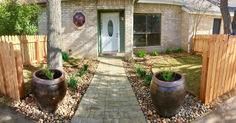 a brick house with two large planters on the front and side of the house