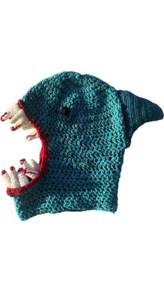 a crocheted hat with an animal's mouth and teeth on the front