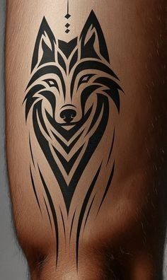 a man's leg with a tattoo design on it, showing the head of a wolf