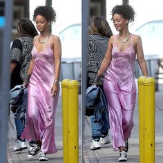 a woman in a pink dress is walking down the street