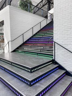 a set of stairs with multicolored lights on the sides and handrails