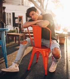 a young man sitting on an orange chair