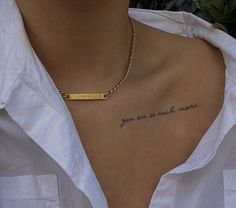 a woman wearing a white shirt has a gold bar on her chest that says, you are so much more