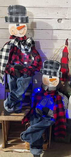 two snowmen sitting next to each other on a bench