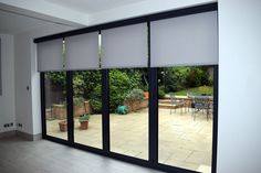 an open sliding glass door with patio furniture in the background