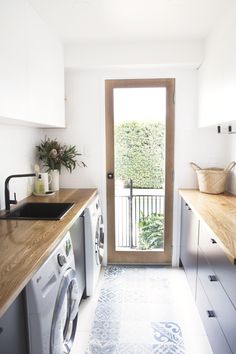 a washer and dryer sitting in a kitchen next to a door that leads to a balcony