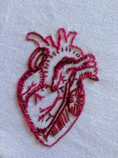 embroidered heart on white fabric with pink thread