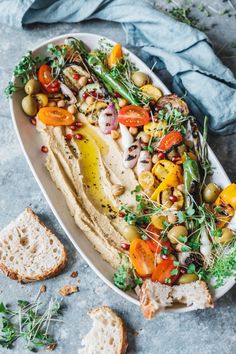 a platter filled with hummus and vegetables