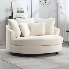 a living room with a round couch and white rug on the floor next to a clock