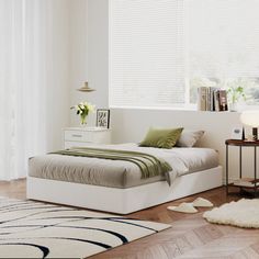 a bedroom with a bed, nightstands and rug on the floor in front of a window