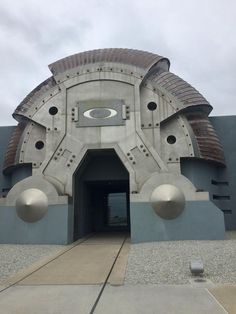 an entrance to a building with two large metal balls on it's face and the door is open