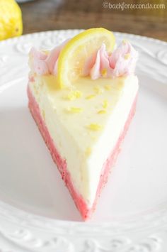 a slice of cake on a white plate with pink and yellow icing next to it