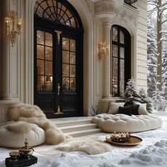 a living room filled with lots of furniture and snow covered trees in front of it