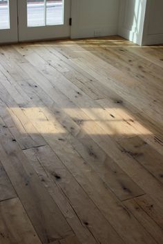 an empty room with wooden floors and doors