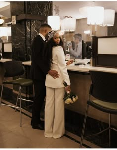 a man and woman standing next to each other in front of a counter