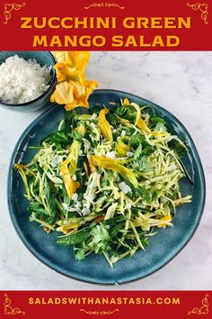 a blue plate topped with green salad next to a bowl of rice and an orange flower