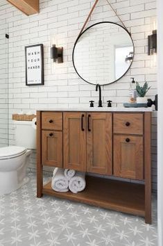 a bathroom with white brick walls and black and white flooring, including a wooden vanity