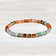 Delicate gemstone bracelet made with carnelian, tiger’s eye, labradorite, and African turquoise. Lightweight and comfortable. Strung on our exclusive thick hitec elastic. Available in 3 sizes. Made in the USA. Carnelian restores vitality and motivation and stimulates creativity. It gives courage, promotes positive life choices, dispels apathy, and motivates for success. African Turquoise is a type of Jasper that has the look of an earthy Turquoise, it is said to bring encouragement for growth, d Healing Carnelian Beaded Bracelets With Natural Stones, Carnelian Beaded Bracelets With Natural Stones For Meditation, Orange Carnelian Gemstone Bead Bracelets, Orange Carnelian Bracelets With Natural Stones, Orange Agate Gemstone Bead Bracelets, Bohemian Carnelian Gemstone Beaded Bracelets, Orange Agate Gemstone Bracelets, Orange Agate Gemstone Beads Bracelet, Adjustable Orange Natural Stone Beaded Bracelets