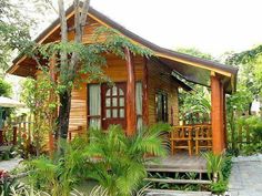 a small wooden house surrounded by greenery and trees