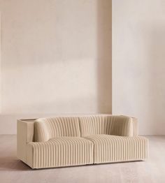 a white couch sitting on top of a hard wood floor next to a tall wall