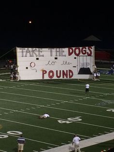 a football field with people on it and a sign that says take the dogs to the pound