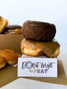 donuts are stacked on top of each other with a sign that says don't forget to pray