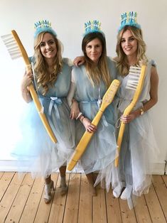 three women dressed up in costumes holding brooms and toothbrushes while standing next to each other