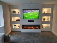 a living room with a large flat screen tv mounted on the wall next to a fire place