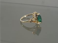 This is a gorgeous bypass ring crafted from 14k yellow gold that features one synthetic marquise chrome diopside accented with two tiny round faceted diamonds on each side. This ring would make a great engagement, promise, anniversary, or right-hand ring. This ring will be shipped in a brand new gift box. RING SIZE: 7.0 (Sizable by your local jeweler) Metal: 14k yellow gold (Verified by acid test) Gemstone: 1 Marquise Synthetic Chrome Diopside (approx. 10.0mm x 5.0mm) & 4 round faceted diamo Classic Marquise Cut May Birthstone Jewelry, Classic Marquise May Birthstone Jewelry, Classic Marquise Jewelry For May Birthstone, Formal Marquise Cut May Birthstone Jewelry, Heirloom Style Marquise May Birthstone Jewelry, Formal Green Marquise Jewelry, Marquise Cut Jewelry With Accent Stones For May Birthstone, Heirloom Marquise May Birthstone Jewelry, Classic Marquise Birthstone Jewelry