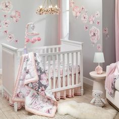 This beautiful reversible floral themed baby bedding nursery set comes complete with a quilt, 100% cotton fitted crib sheet, pom pom trimmed crib skirt and a complete set of wall decals. These gorgeous blossoming flowers are in shades of soft pink with gray accents. It looks like an exquisite watercolor painting and has a border of a linen rayon blend. Pretty pink pom poms decorate the entire quilt and the reverse side is a gray ground with all the pretty coordinating flowers. The 100% cotton fi Floral Crib Bedding, Lambs & Ivy, Baby Crib Bedding Sets, Floral Wall Decals, Girl Nursery Room, Baby Crib Bedding, Bedding Sets Online, Nursery Bedding Sets, Crib Bedding Sets