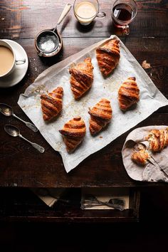 some croissants are sitting on a table next to a cup of coffee