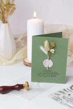 a greeting card with a flower on it next to a candle and some other items