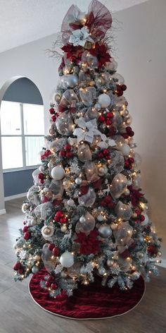 a white christmas tree with red and silver ornaments