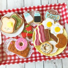 an assortment of breakfast foods on a red and white checkered tray