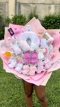 a woman holding a bouquet of baby items