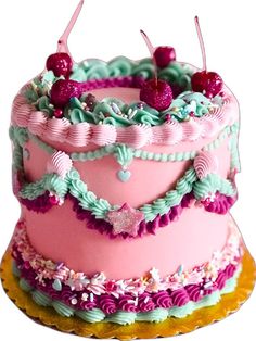 a pink and green cake with cherries on top