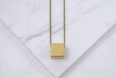 A simple vintage cube charm (12 mm wide) that I strung directly onto a nickel free aged-brass chain. It looks cool on its own, but you could also layer it because of how minimal it is. It's fun to wear because it's such a recognizable shape, but how often do you see it in jewelry? The charm you receive will have slight age spots, making each one unique. It looks vintage because it is! *If you prefer a different length, just let me know during checkout!* ► DETAILS: Chain length: 24 inches (61 cm) Minimalist Rectangular Jewelry For Everyday Use, Minimalist Rectangular Necklace For Everyday Use, Minimalist Rectangular Everyday Jewelry, Minimalist Square Jewelry With Adjustable Chain, Minimalist Square Pendant Necklaces, Minimalist Adjustable Square Pendant Necklace, Minimalist Rectangular Brass Jewelry, Minimalist Square Pendant Gemstone Necklace, Minimalist Brass Necklace With Square Pendant