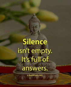 a buddha statue sitting on top of a table next to yellow flowers and a quote that reads