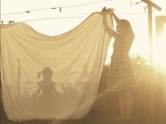 two women are standing in front of a white curtain