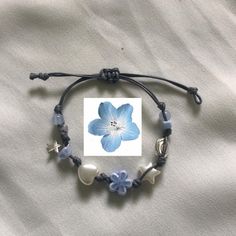 a blue flower is on a string with other beads and charms attached to the cord