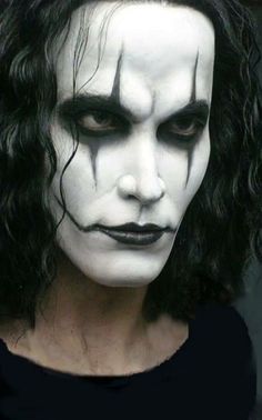 a man with black hair and white makeup