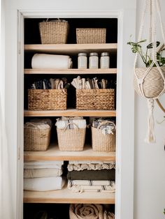 an organized closet with baskets and towels