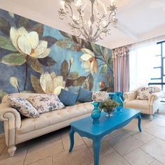 a living room filled with furniture and a chandelier above a blue coffee table