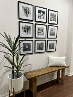 a wooden bench sitting next to a wall with pictures on it