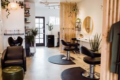 a hair salon with chairs, mirrors and plants